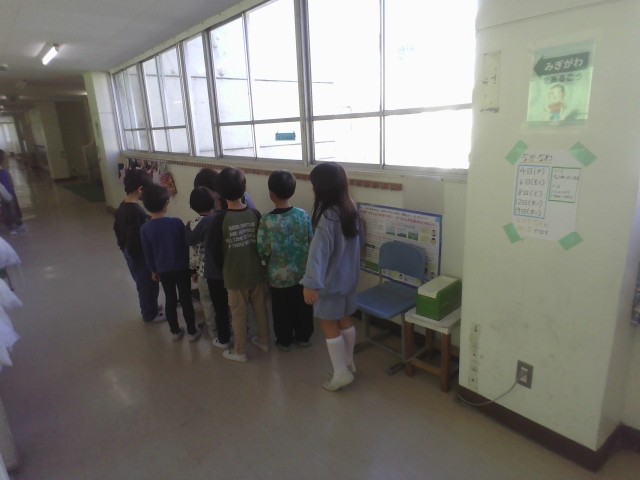 どんぐりの穴開けを先生に頼む列